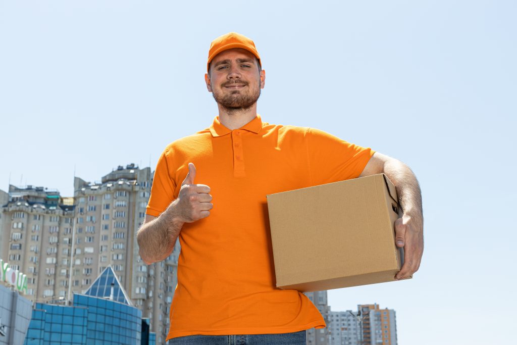 Happy mover in an orange uniform holding a package