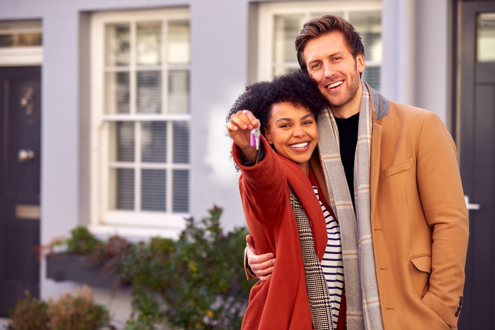 Couple in fall colors with keys to a new home