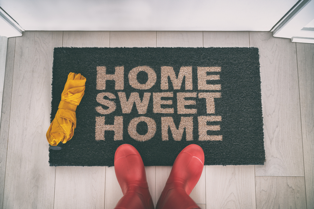 Fall moving tips concept with a welcome mat and boots