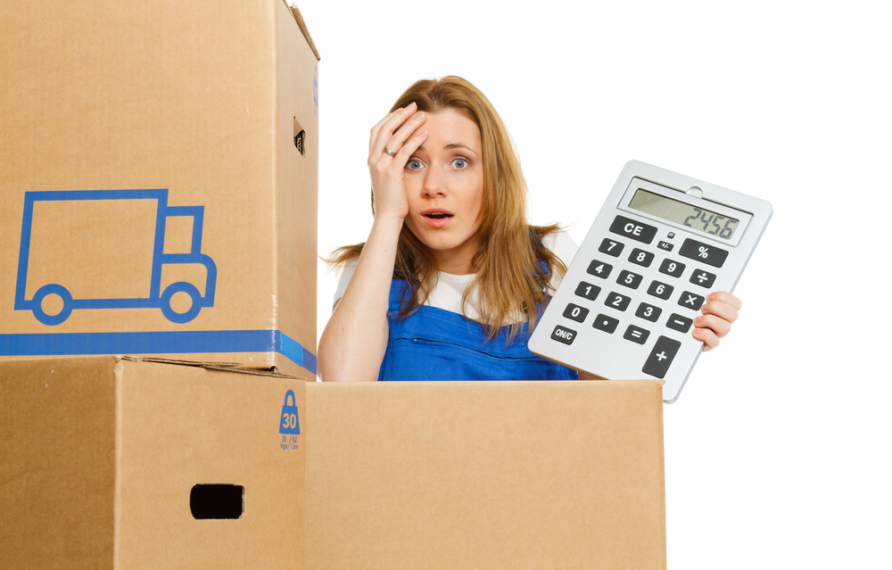 Woman stressed after receiving a moving estimate next to boxes